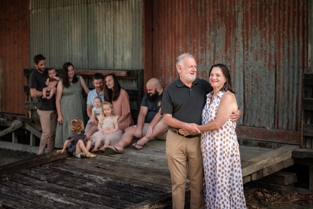 Grandparents photographed with their children and grandchildren behind them