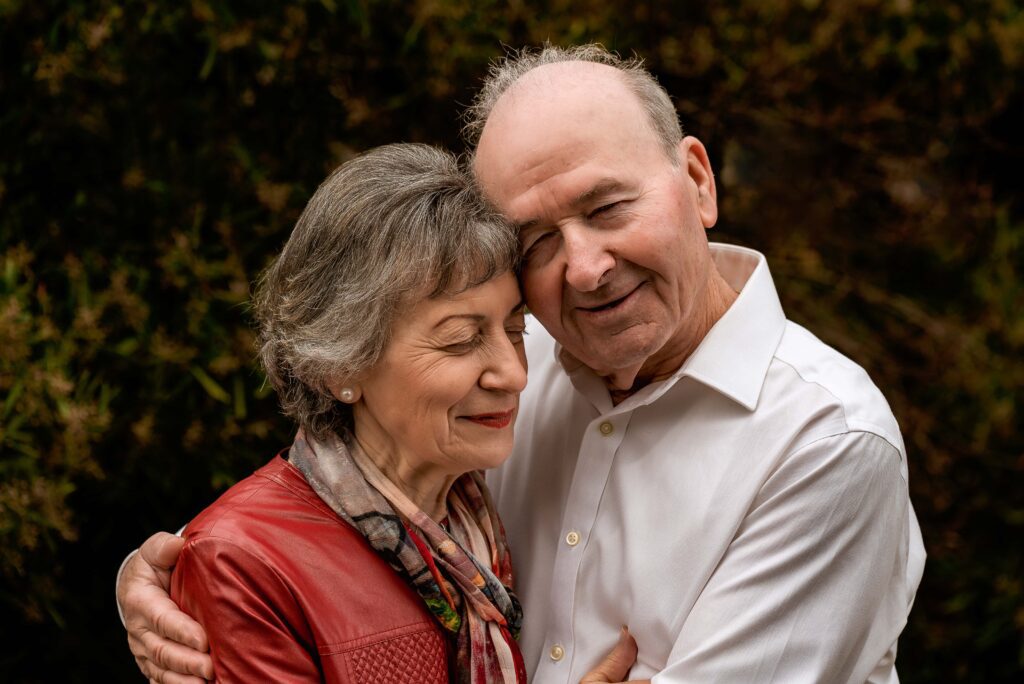 Grandparents holding each other with eyes closed