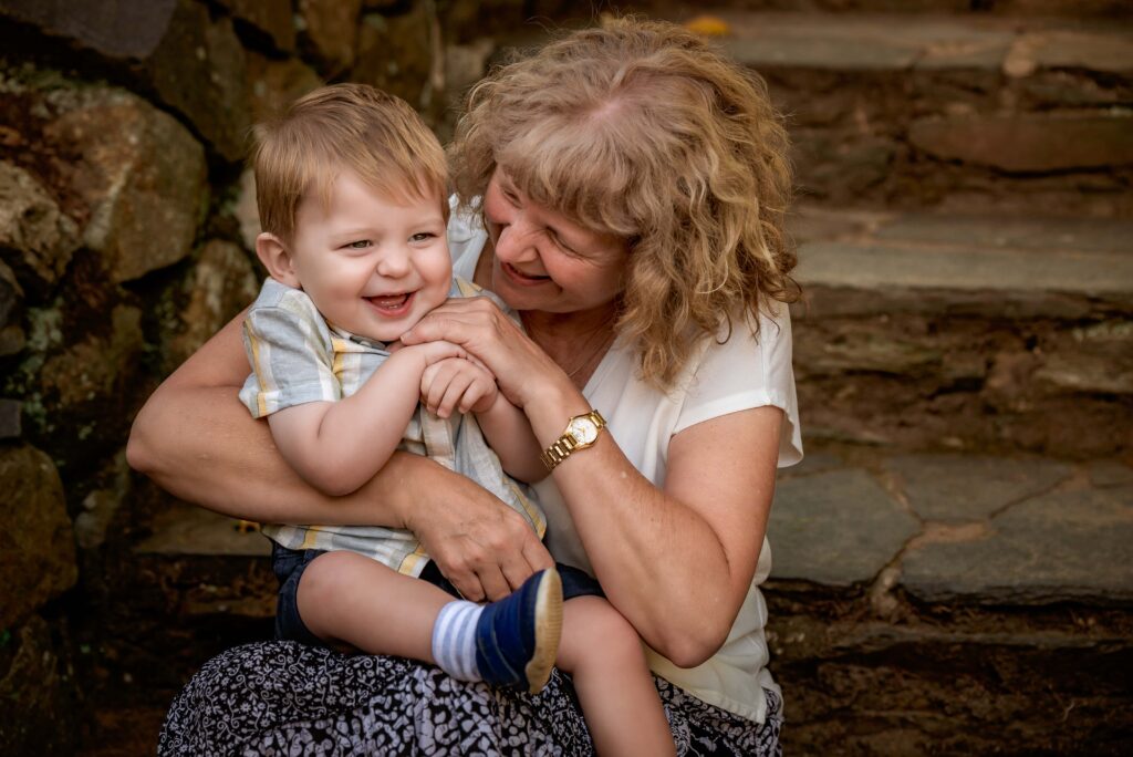 Grandmother tickling her toddler grandson at Alfred Nicholas Gardens
