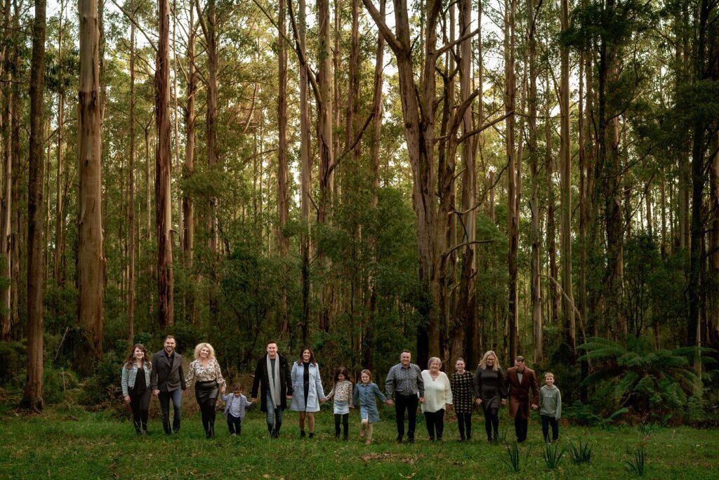 Extended family walking towards the camera with forest of Dandenongs behind them