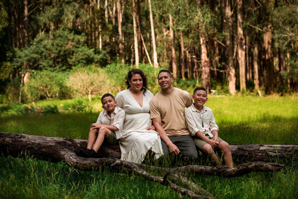 Family of four sitting on a log at Dandenong Ranges National Park