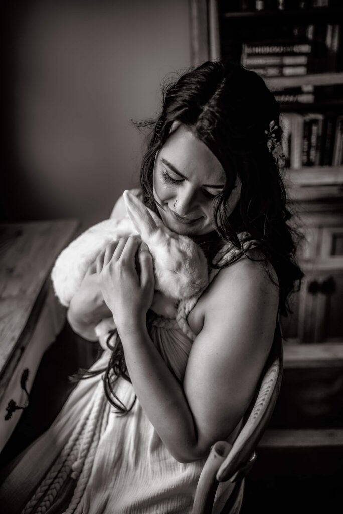 Black and white bridal portrait of her holding her pet rabbit