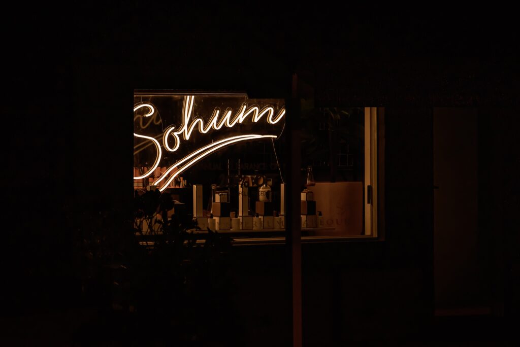 Window of Sohum in Sassafras taken at night with neon sign lit up
